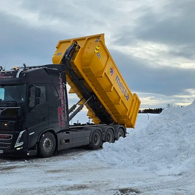 Lastebil som losser av snø